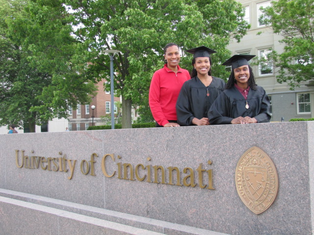 Jamelle Elliott with two Cincinnati graduates at the University of Cincinnati sign