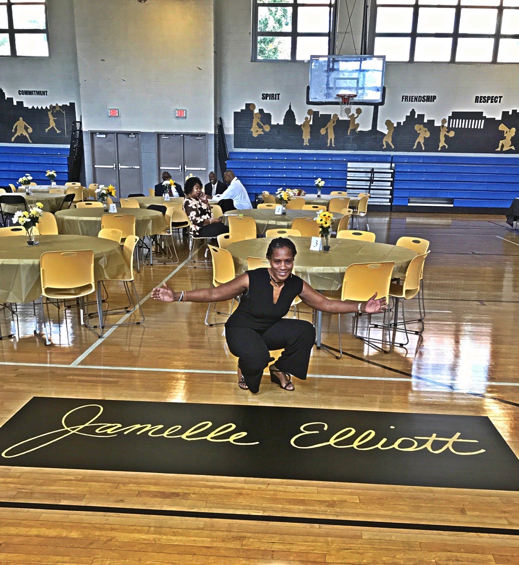Jamelle Elliott kneeling on her named court at John Hayden Johnson Middle School